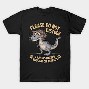 A whimsical cartoon drawing of a disheveled t-rex, with its fur sticking out in all directions and large yellow eyes showing irritation. T-Shirt